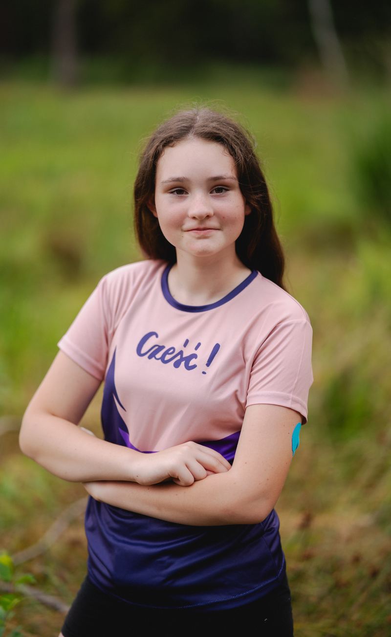 Mädchen in einem rosa-marineblauen bedruckten Sportshirt