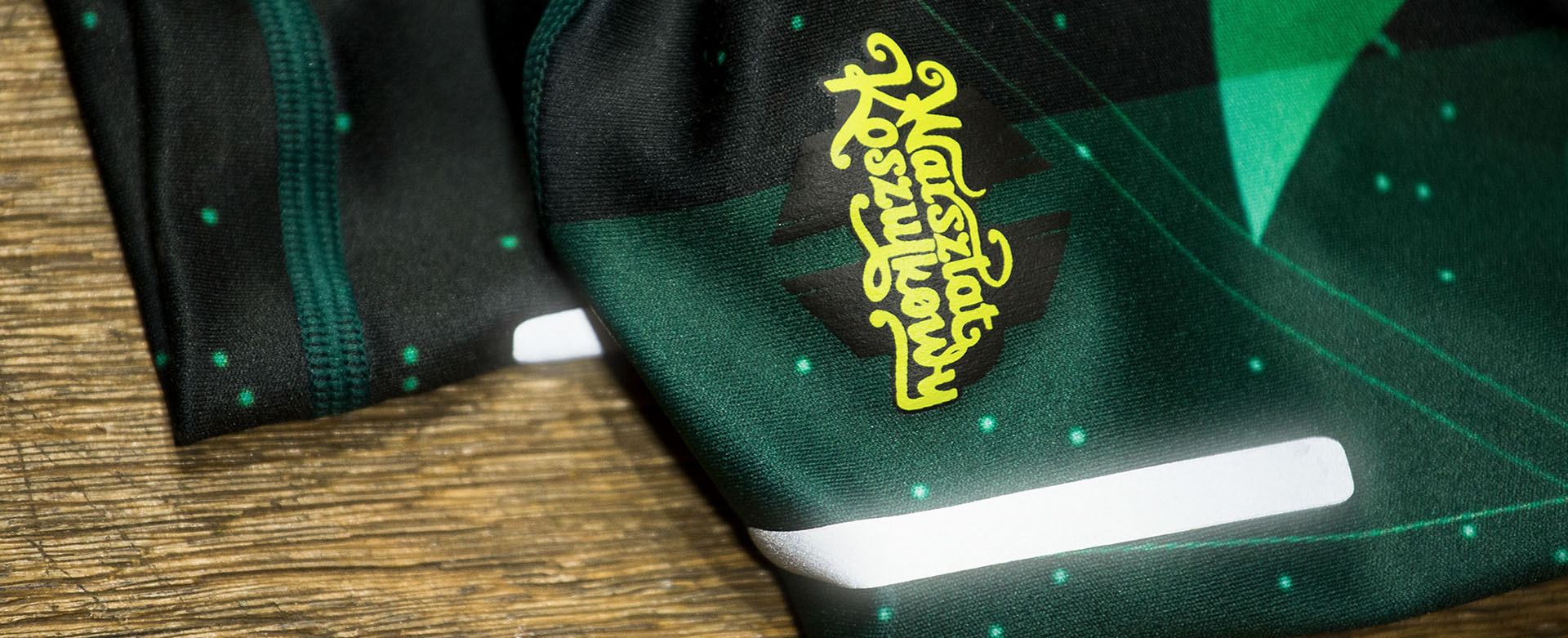 Grüner sublimierter Ärmel mit Reflexstreifen und aufgedrucktem Logo